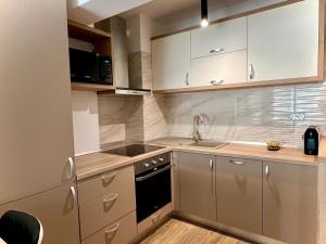 克卢日-纳波卡MM Residence的厨房配有白色橱柜和水槽
