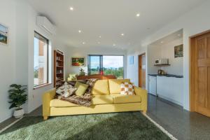 TasmanCountryview Haven的一间带黄色沙发的客厅和一间厨房