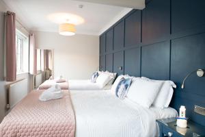 戈尔韦阿黛尔宾馆的卧室设有两张床铺和蓝色的墙壁