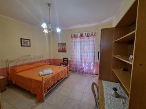 锡巴里Casa Sibarys 20 mt dalla Stazione piano terra的一间卧室配有带橙色床单的床和窗户。
