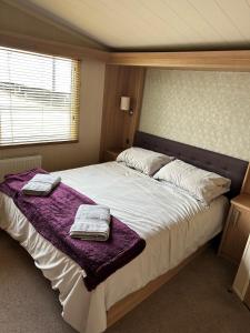 浦耳Sea Breeze Cabin的一间卧室配有一张大床和两条毛巾