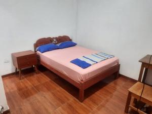 伊基托斯Casa Grande的铺有木地板的客房内的一张小床