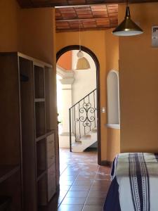 瓜亚比托斯Mountain View Lofts Guayabitos的一间设有一张床的客房和一个带楼梯的走廊