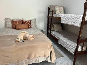南圣弗朗西斯科Suítes Recanto Monte trigo的一间卧室设有两张双层床和一张带枕头的床。
