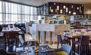 欧文DFW机场君悦酒店的一间带桌椅的餐厅和一间厨房
