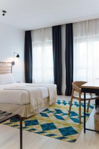 马德里7岛酒店的一间卧室配有一张床、一张桌子和一张地毯。