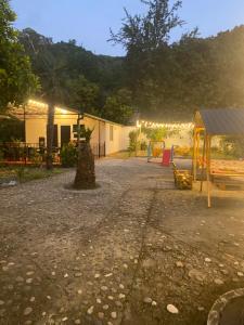 高尼奥Maguli Home Gonio的一个带游乐场的公园和一个带灯光的建筑