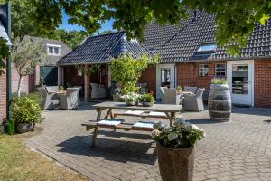 泽伊德拉伦Hotel B&B Hoeve de Vredenhof的庭院配有木制野餐桌和椅子