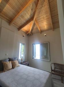 阿斯塔科斯By the sea的一间卧室设有一张带木制天花板的大床