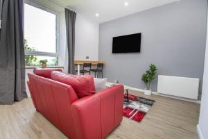 阿伯丁The Ojay's - Gustina Apartment的客厅配有红色沙发和电视