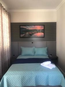 波梅罗迪Pousada Kaki Haus的一间卧室配有一张带蓝色床单的大床