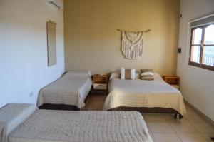 卡法亚特La Justina - Alquiler Temporario的带三张床和窗户的客房