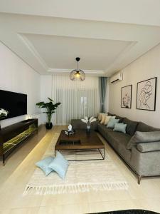 莫纳斯提尔A Luxury 2BR with Big Pools Perfect for Family Summer Escape!的带沙发和咖啡桌的客厅