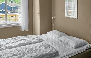 尤坎2 Bedroom Amazing Apartment In Rjukan的卧室内的一张未铺好的床,设有窗户