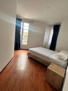 波哥大Hotel Artistico的一间卧室配有一张床,铺有木地板