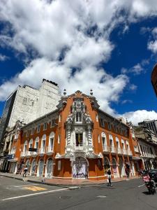 波哥大Hotel Artistico的街道边的一座橙色大建筑