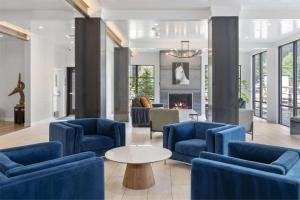 弗瑞斯科Cambria Hotel Copper Mountain的客厅配有蓝色椅子和壁炉