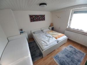 布拉河畔的海登海姆FeWo Heidenheim Bluewall的卧室配有白色的床和窗户。