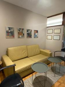 加亚新城Jardim do Morro Places的客厅设有黄色的沙发和2张桌子