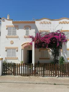 拉戈斯Villa 46 Hostel的白色房子前面有紫色的花