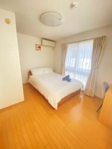 东京田端民泊ー田端ハウス的一间卧室设有一张床和一个大窗户