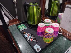 塞维利亚巴克酒店的一张桌子,上面放着两个绿咖啡壶和纱线