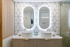 努萨角诺萨蓝色度假酒店的浴室设有2个水槽和2面镜子