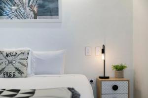努萨角诺萨蓝色度假酒店的白色卧室配有床和灯