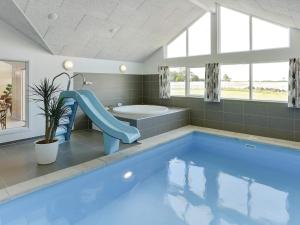 博恩瑟Holiday home Bogense XLII的一间带蓝色游泳池及滑梯的浴室