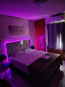 萨尔瓦多Apartamento único na praia do Farol de Itapuã的一间卧室配有一张紫色灯床