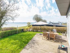 奥本罗Holiday home Aabenraa LXXIV的一个带桌椅的庭院和一个草坪