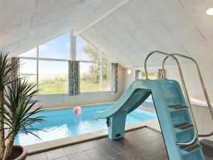 SønderbyHoliday home Sydals LXXXVI的一个带游泳池的房间的滑梯