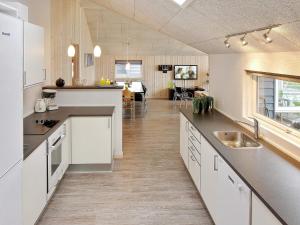 SønderbyHoliday home Sydals LXXXVI的一间大厨房,配有白色的橱柜和一间餐厅
