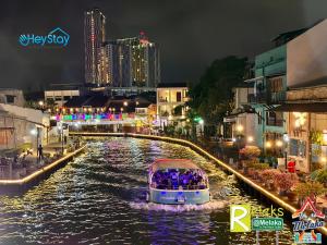 马六甲Wayfarer Guest House Jonker Street Melaka By Heystay Management的夜空在城市的河流上