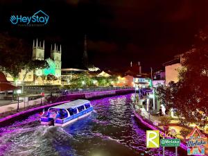 马六甲Wayfarer Guest House Jonker Street Melaka By Heystay Management的夜间沿河航行的船只