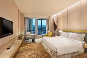 武清天津武清金泰假日酒店的酒店客房设有一张大床和一张书桌。