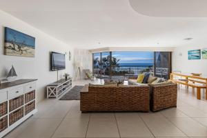 黄金海岸岩石度假村，3C号度假屋的带沙发、桌子和电视的客厅