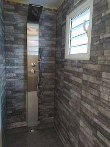 圣丹尼斯Appartement t3 rdc的带淋浴的浴室,浴室设有砖墙