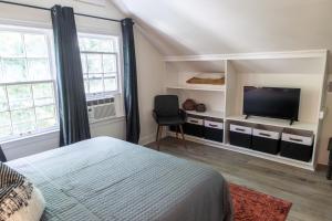 孟菲斯J Birds' Cottage Midtown Memphis的一间卧室配有一张床和一台平面电视