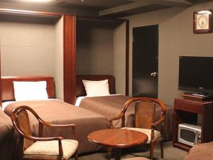 横滨HOTEL LiVEMAX BUDGET Yokohama Tsurumi的一间酒店客房,设有两张床和电视