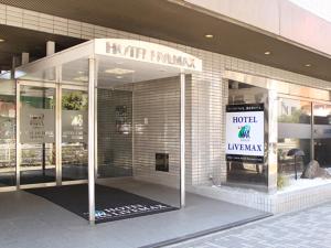 横滨HOTEL LiVEMAX BUDGET Yokohama Tsurumi的窗户上标有标志的酒店入口