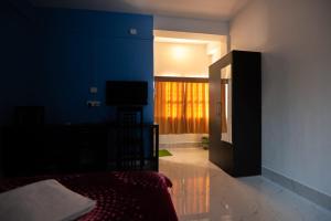 卡齐兰加Jungle Eco Mansion的一间卧室配有一张床和一台电视。