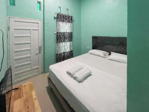 PangururanAntony Homestay near Pantai Pasir Putih Parbaba Mitra RedDoorz的卧室配有带毛巾的大型白色床