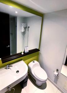 波哥大68号斯卡拉酒店的一间带卫生间、水槽和镜子的浴室