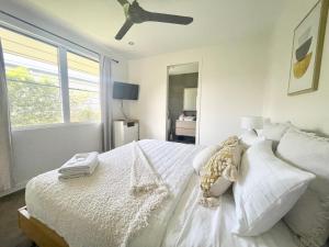 克瓦拉海滩Ranch Retreat的卧室配有白色的床和吊扇