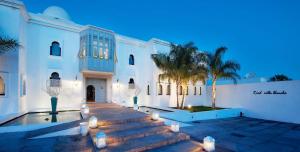 阿加迪尔布兰奇别墅摩洛哥传统庭院住宅酒店的白色的建筑,晚上有楼梯和棕榈树
