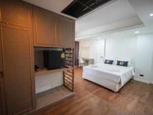 曼谷WellQuest Wellness Ladprao Soi 1的一间卧室配有一张床和一台平面电视