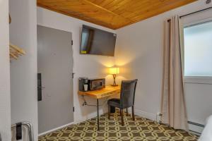 安克雷奇Highliner Hotel - Deluxe Interior King Rooms- No View的客房设有带微波炉的书桌和椅子。