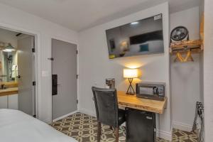 安克雷奇Highliner Hotel - King Rooms with City & Park Views的一间卧室配有一张书桌、微波炉和一张床