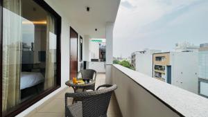 古尔冈BluO 3BHK Golf Course Road - Balcony, Lift, Terrace的阳台配有两把椅子和一张桌子